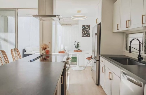 Mission Hills Apartment | Discover the work of modernist architect Homer Delawie at the Hillside Hideaway. This unique downstairs unit reflects his renowned style of simplicity, using large glass areas to seamlessly blend the living space with the natural surroundings.