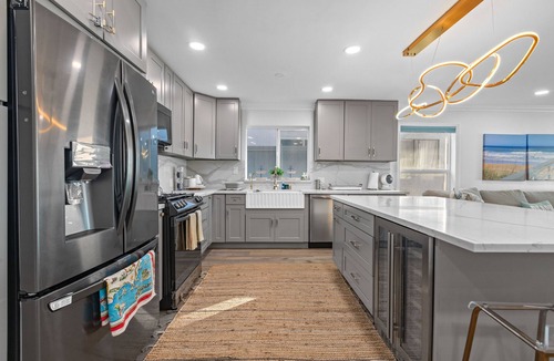 Alamitos Beach House | Oceanfront retreat with rooftop deck, modern interior, marble finishes, & W/D